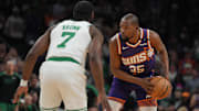 Phoenix Suns forward Kevin Durant shields the ball from Boston Celtics guard Jaylen Brown during the first half