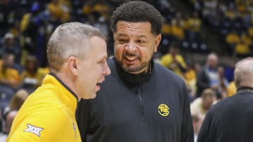 Nov 13, 2025; Morgantown, West Virginia, USA; Pittsburgh Panthers head coach Jeff Capel III talks to West Virginia Mountaineers head coach Ross Hodge before the game at WVU Coliseum. Mandatory Credit: Ben Queen-Imagn Images