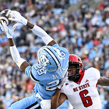 Nov 30, 2024; Chapel Hill, North Carolina, USA; North Carolina Tar Heels defensive back Marcus Allen (29) intercepts the ball in the end zone intended for North Carolina State Wolfpack wide receiver Wesley Grimes (6) in the first quarter at Kenan Memorial Stadium. Mandatory Credit: Bob Donnan-Imagn Images