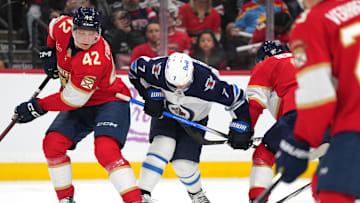Nov 16, 2024; Sunrise, Florida, USA;  Winnipeg Jets center Vladislav Namestnikov (7) and Florida Panthers defenseman Gustav Forsling (42) battle for possession during the first period at Amerant Bank Arena. Mandatory Credit: Jim Rassol-Imagn Images