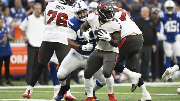 Aug 27, 2022; Indianapolis, Indiana, USA; Tampa Bay Buccaneers running back Leonard Fournette (7) tries to evade Indianapolis Colts defensive tackle Grover Stewart (90) during the first quarter of the game at Lucas Oil Stadium. Mandatory Credit: Marc Lebryk-USA TODAY Sports