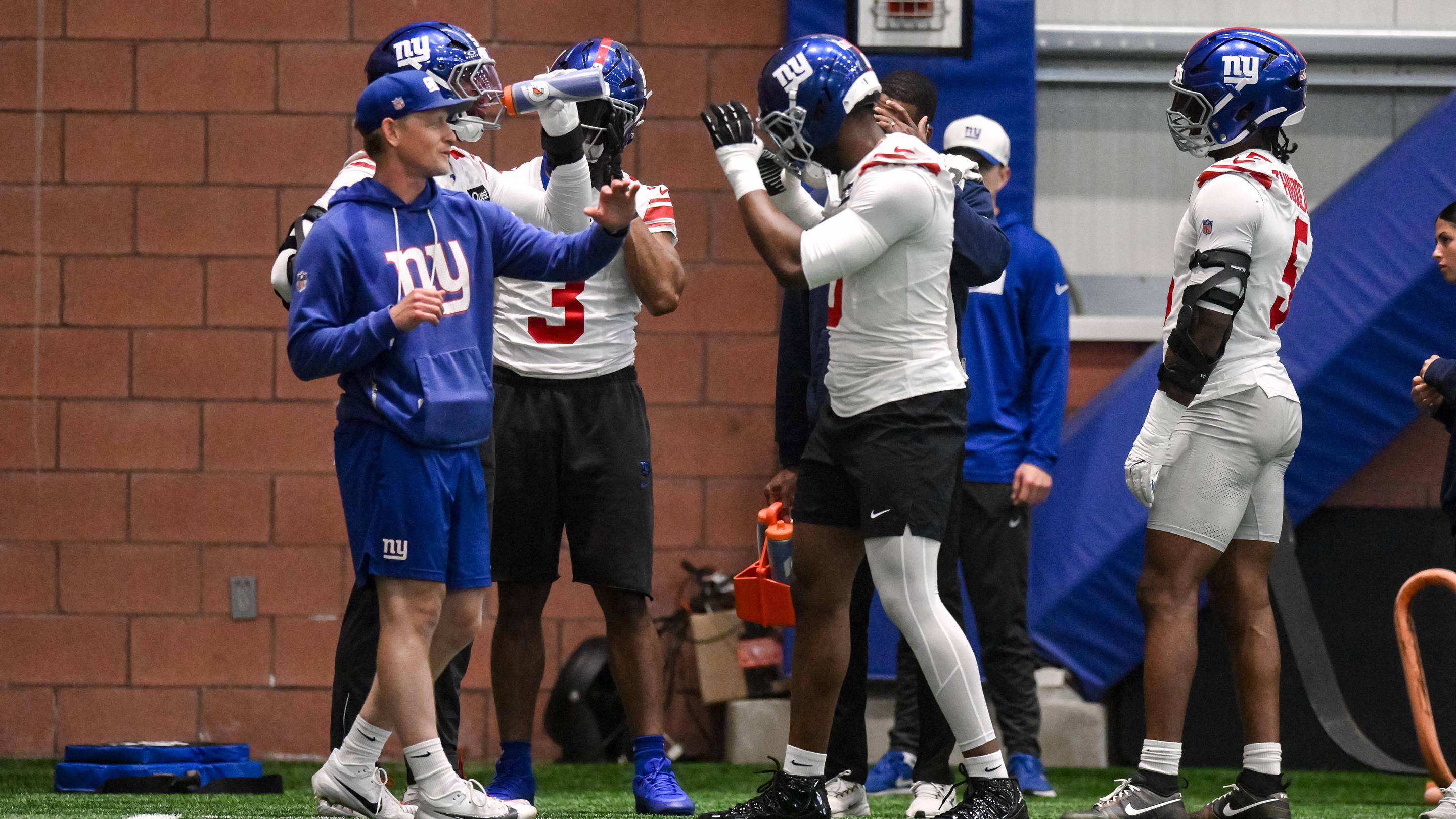 May 21, 2026; East Rutherford, NJ, USA; New York Giants linebacker Brian Burns (0) and outside linebackers coach Charlie Bullen react during organized team activities at Quest Diagnostics Training Center.