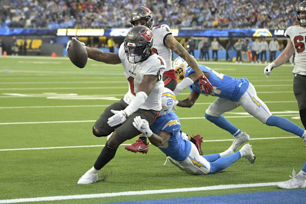 Tampa Bay Buccaneers running back Rachaad White drags Los Angeles Chargers cornerback Tarheeb Still into the end zone.