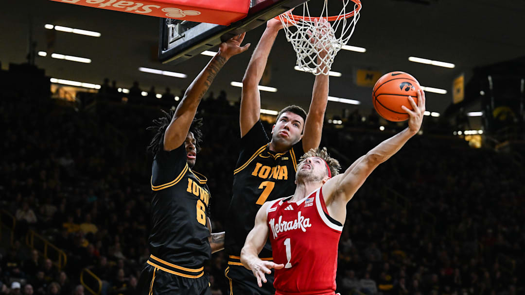Feb 17, 2026; Iowa City, Iowa, USA; Nebraska Cornhuskers guard Sam Hoiberg (1) goes to the basket as Iowa Hawkeyes forward Alvaro Folgueiras (rear) and guard Tavion Banks (6) defend during the first half at Carver-Hawkeye Arena. Mandatory Credit: Jeffrey Becker-Imagn Images