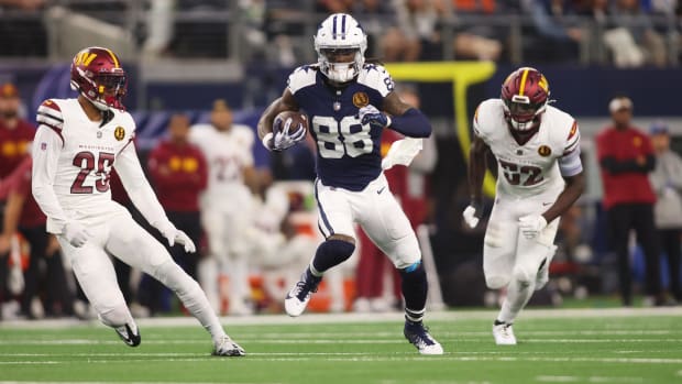 Dallas Cowboys receiver CeeDee Lamb attempts to evade Washington Commanders defenders Benjamin St-Juste and Jamin Davis.