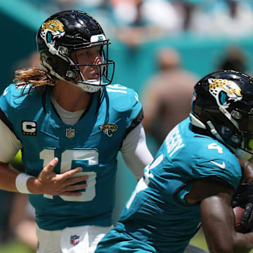 Sep 8, 2024; Miami Gardens, Florida, USA;  Jacksonville Jaguars quarterback Trevor Lawrence (16) hands off to running back Tank Bigsby (4) in the first quarter against the Miami Dolphins at Hard Rock Stadium. Mandatory Credit: Jim Rassol-Imagn Images