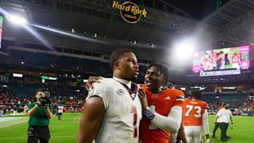 Sep 27, 2024; Miami Gardens, Florida, USA; Miami Hurricanes quarterback Cam Ward (1) and Virginia Tech Hokies quarterback Kyron Drones (1) talk on the field after the game at Hard Rock Stadium. Mandatory Credit: Sam Navarro-Imagn Images