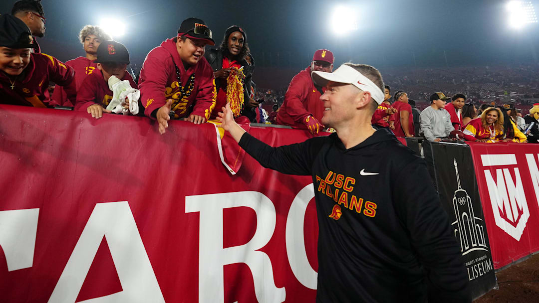 Nov 29, 2025; Los Angeles, California, USA; Southern California Trojans head coach Lincoln Riley celebrates with fans after the game against the UCLA Bruins at United Airlines Field at Los Angeles Memorial Coliseum. Mandatory Credit: Kirby Lee-Imagn Images