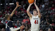 Dec 8, 2024; Cincinnati, Ohio, USA; Cincinnati Bearcats guard Simas Lukosius (41) attempts a 3-point shot against Howard Bison guard Marcus Dockery (5) in the first half at Fifth Third Arena. Mandatory Credit: Aaron Doster-Imagn Images