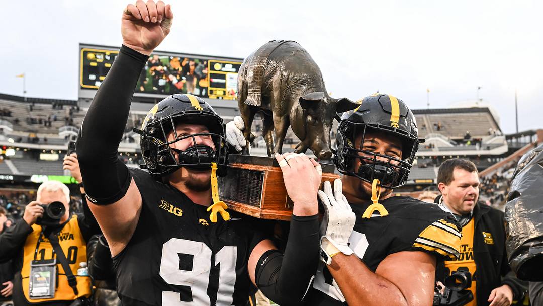 Oct 25, 2025; Iowa City, Iowa, USA; Iowa Hawkeyes defensive lineman Jonah Pace (91) and defensive lineman Bryce Hawthorne (96) carry off the Floyd of Rosedale trophy after their victory over the Minnesota Golden Gophers at Kinnick Stadium. 