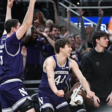Mar 12, 2025; Indianapolis, IN, USA; Northwestern Wildcats forward Luke Hunger (33), Northwestern Wildcats center Keenan Fitzmorris (5) and Northwestern Wildcats guard Angelo Ciaravino (44) celebrate from the bench after a play during the second half against the Minnesota Golden Gophers at Gainbridge Fieldhouse. Mandatory Credit: Robert Goddin-Imagn Images