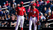 Cincinnati Reds catcher Chuckie Robinson (67) stands at first with first base coach Collin Cowgill (54) after reaching on a bunt in the eighth inning of the MLB Cactus League spring training game between the Cincinnati Reds and the Cleveland Guardians at Goodyear Ballpark in Goodyear, Ariz., on Saturday, Feb. 25, 2023.

Cleveland Guardians At Cincinnati Reds Spring Training