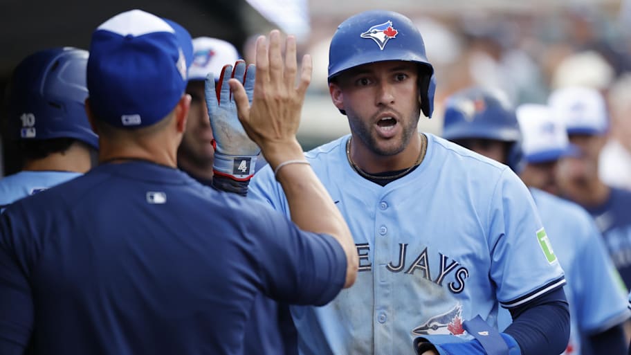 George Springer high-fives teammates after a run against the Tigers. | Rick Osentoski-Imagn Images
