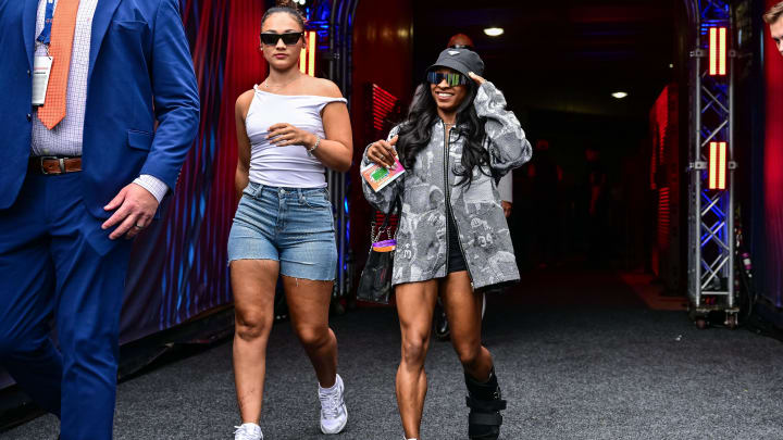 Aug 17, 2024; Chicago, Illinois, USA; United States gymnast Simone Biles, right, enters the field before the game between the Chicago Bears and the Cincinnati Bengals at Soldier Field. 