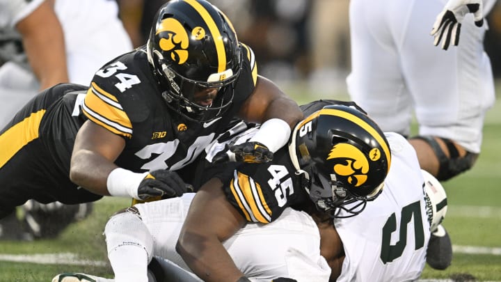 Sep 30, 2023; Iowa City, Iowa, USA; Iowa Hawkeyes linebacker Jay Higgins (34) and defensive lineman Deontae Craig (45) tackle Michigan State Spartans running back Nathan Carter (5) during the first quarter at Kinnick Stadium. Mandatory Credit: Jeffrey Becker-USA TODAY Sports