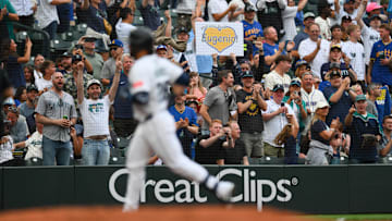 Aug 5, 2025; Seattle, Washington, USA; A fan holds up a sign after as Seattle Mariners third baseman Eugenio Suarez (28) runs the bases after hitting a 2-run home run against the Chicago White Sox during the fourth inning at T-Mobile Park. Mandatory Credit: Steven Bisig-Imagn Images
