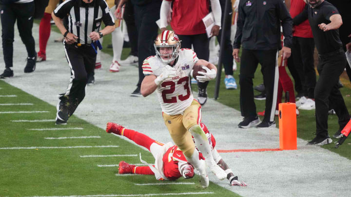 Feb 11, 2024; Paradise, Nevada, USA; San Francisco 49ers running back Christian McCaffrey (23) runs with the ball against Kansas City Chiefs safety Mike Edwards (21) during overtime of Super Bowl LVIII at Allegiant Stadium. Mandatory Credit: Joe Camporeale-USA TODAY Sports