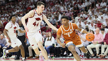 Feb 26, 2025; Fayetteville, Arkansas, USA; Texas Longhorns guard Julian Larry (1) drives against Arkansas Razorbacks forward Zvonimir Ivisic (44) and forward Karter Knox (11) looks on during the second half at Bud Walton Arena. Mandatory Credit: Nelson Chenault-Imagn Images