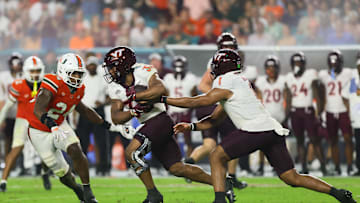 Sep 27, 2024; Miami Gardens, Florida, USA; Virginia Tech Hokies running back Bhayshul Tuten (33) takes a handoff from quarterback Kyron Drones (1) against the Miami Hurricanes during the fourth quarter at Hard Rock Stadium. Mandatory Credit: Sam Navarro-Imagn Images
