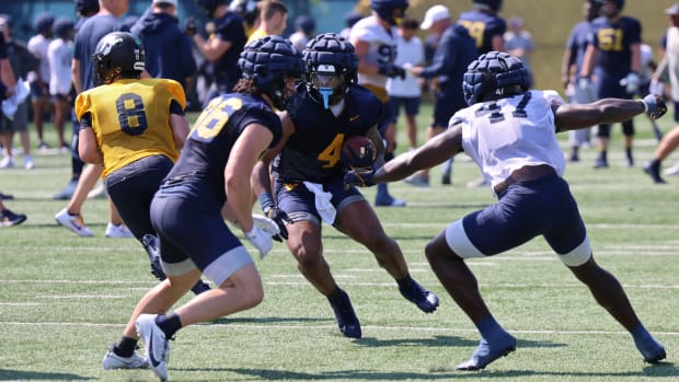 West Virginia University running back CJ Donaldson splits the defense during fall camp (2024). 