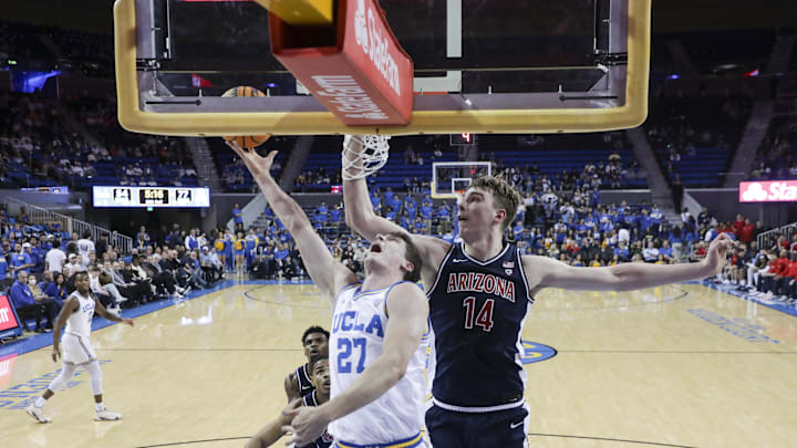 Mar 7, 2024; Los Angeles, California, USA; UCLA guard Jan Vide (27) attempts a layup as Arizona Wildcats center Motiejus Krivas (14) defends during the second half of a game at Pauley Pavilion presented by Wescom. Mandatory Credit: Yannick Peterhans-Imagn Images