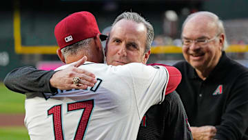 Diamondbacks president Derrick Hall hugs manager Torey Lovullo (17) as the team are passed out National League Championship Rings prior to a game against the Rockies at Chase Field on March 29, 2024.