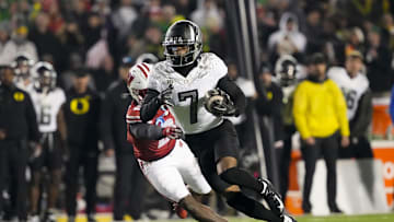 Nov 16, 2024; Madison, Wisconsin, USA;  Oregon Ducks wide receiver Evan Stewart (7) rushes with the football in front of Wisconsin Badgers cornerback Ricardo Hallman (2) after catching a pass during the fourth quarter at Camp Randall Stadium. Mandatory Credit: Jeff Hanisch-Imagn Images