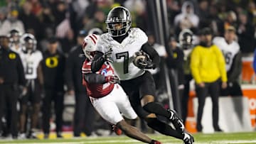 Nov 16, 2024; Madison, Wisconsin, USA;  Oregon Ducks wide receiver Evan Stewart (7) rushes with the football in front of Wisconsin Badgers cornerback Ricardo Hallman (2) after catching a pass during the fourth quarter at Camp Randall Stadium. Mandatory Credit: Jeff Hanisch-Imagn Images