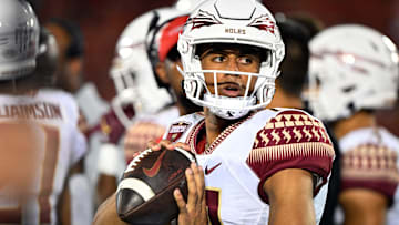 Sep 16, 2022; Louisville, Kentucky, USA;  Florida State Seminoles quarterback Jordan Travis (13) warms up on the sideline against the Louisville Cardinals during the first half at Cardinal Stadium. Florida State defeated Louisville 35-31. Mandatory Credit: Jamie Rhodes-Imagn Images
