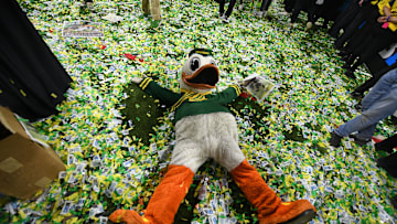 Dec 7, 2024; Indianapolis, IN, USA; The Oregon Duck mascot makes snow angels in confetti after defeating the Penn State Nittany Lions to win the Big Ten Championship in the 2024 Big Ten Championship game at Lucas Oil Stadium. Mandatory Credit: Robert Goddin-Imagn Images