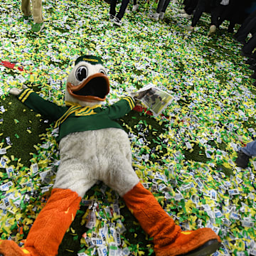 Dec 7, 2024; Indianapolis, IN, USA; The Oregon Duck mascot makes snow angels in confetti after defeating the Penn State Nittany Lions to win the Big Ten Championship in the 2024 Big Ten Championship game at Lucas Oil Stadium. Mandatory Credit: Robert Goddin-Imagn Images