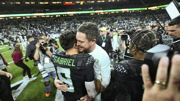 Dec 7, 2024; Indianapolis, IN, USA; Oregon Ducks head coach Dan Lanning hugs quarterback Dillon Gabriel (8) after defeating t