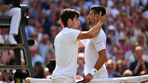 Carlos Alcaraz and Novak Djokovic hug after their match.