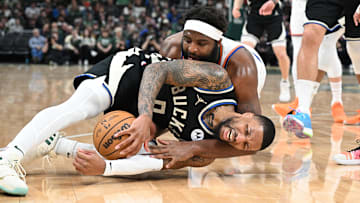 Apr 7, 2024; Milwaukee, Wisconsin, USA; Milwaukee Bucks guard Damian Lillard (0) and New York Knicks center Mitchell Robinson (23) battle for a loose ball in the first half at Fiserv Forum. Mandatory Credit: Michael McLoone-Imagn Images
