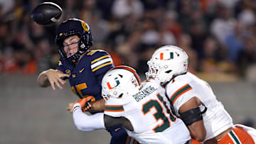 Oct 5, 2024; Berkeley, California, USA; Miami Hurricanes linebacker Wesley Bissainthe (31) and defensive back Jaden Harris (right) force an incomplete pass by California Golden Bears quarterback Fernando Mendoza (left) during the third quarter at California Memorial Stadium. Mandatory Credit: Darren Yamashita-Imagn Images