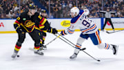 Jan 18, 2025; Vancouver, British Columbia, CAN; Edmonton Oilers forward Connor McDavid (97) shoots around Vancouver Canucks defenseman Tyler Myers (57) in the first period at Rogers Arena. Mandatory Credit: Bob Frid-Imagn Images