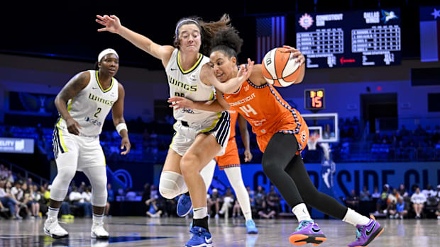 Connecticut Sun guard Bria Hartley is fouled by Dallas Wings forward Maddy Siegrist while dribbling