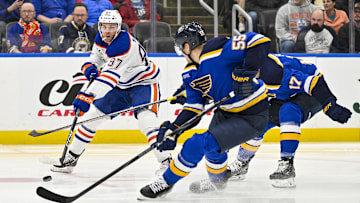 Feb 4, 2025; St. Louis, Missouri, USA;  Edmonton Oilers center Connor McDavid (97) passes the puck as St. Louis Blues defenseman Colton Parayko (55) defends during the first period at Enterprise Center. Mandatory Credit: Jeff Curry-Imagn Images