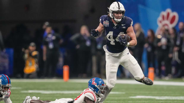 Penn State tight end Tyler Warren runs with the football as an Ole Miss player tries to tackle him in the Peach Bowl.