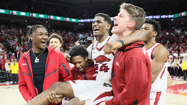 Arkansas Razorbacks forward Adou Thiero (not dressed, left) helps carry forward Billy Richmond III (24) off of the court