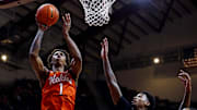 Jan 4, 2025; Blacksburg, Virginia, USA; Virginia Tech Hokies forward Tobi Lawal (1) shoots the ball against Miami Hurricanes forward Brandon Johnson (2) during the first half at Cassell Coliseum. Mandatory Credit: Peter Casey-Imagn Images