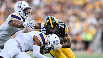 Aug 30, 2025; Iowa City, Iowa, USA; Iowa Hawkeyes running back Kamari Moulton (28) runs the ball as Albany Great Danes defensive back Cam Stodghill (1) and defensive back Denzel Patrick (2) make the tackle during the first quarter at Kinnick Stadium. Mandatory Credit: Jeffrey Becker-Imagn Images
