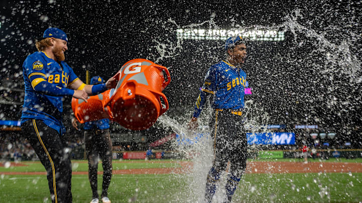 Seattle Mariners designated hitter Justin Turner (2), left, and right fielder Victor Robles (10), second from left, douse centerfielder Julio Rodriguez (44) with water after a game against the Texas Rangers at T-Mobile Park on Sept 13.