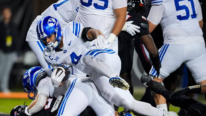 Nov 22, 2025; Cincinnati, Ohio, USA; BYU Cougars running back LJ Martin (4) carries the ball for a touchdown against the Cincinnati Bearcats in the second half at Nippert Stadium. Mandatory Credit: Aaron Doster-Imagn Images