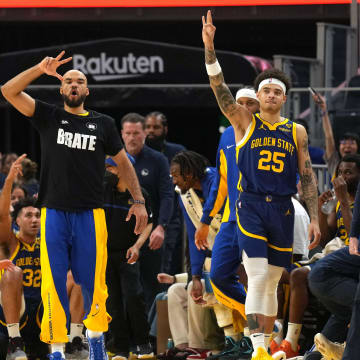 Feb 23, 2024; San Francisco, California, USA; Golden State Warriors guards Jerome Robinson (center left) and Lester Quinones (25) react after a three point basket by guard Stephen Curry (30) during the second quarter against the Charlotte Hornets at Chase Center. Mandatory Credit: Darren Yamashita-USA TODAY Sports