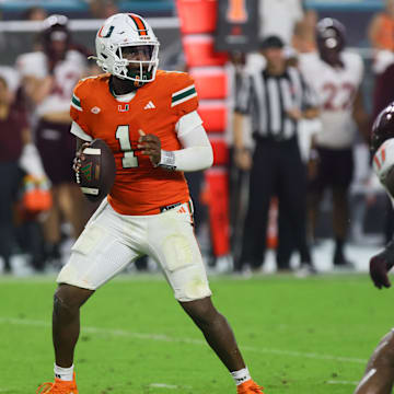 Sep 27, 2024; Miami Gardens, Florida, USA; Miami Hurricanes quarterback Cam Ward (1) looks for a passing option against the Virginia Tech Hokies during the fourth quarter at Hard Rock Stadium. Mandatory Credit: Sam Navarro-Imagn Images