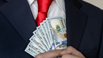 A businessman holding 100 dollar bills.