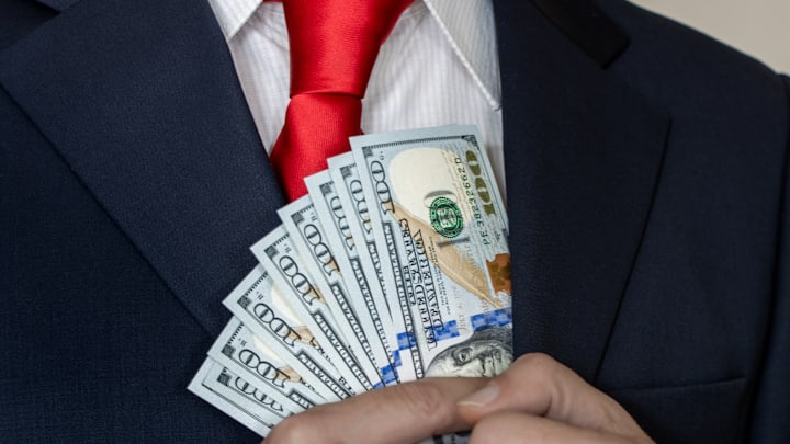 A businessman holding 100 dollar bills.