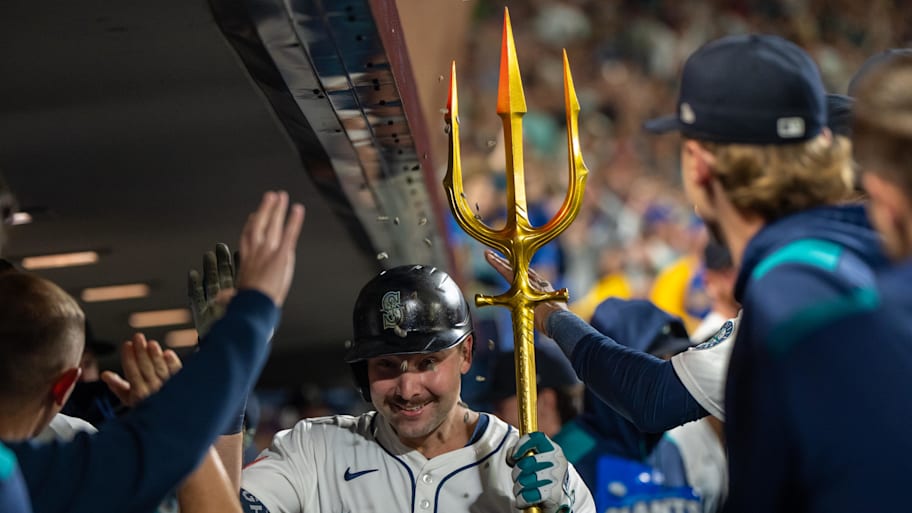 Seattle Mariners catcher Cal Raleigh celebrates in the dugout after hitting a solo home run.