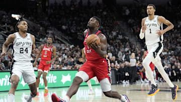 Dec 17, 2023; San Antonio, Texas, USA; New Orleans Pelicans Zion Williamson (1) drives to the basket past San Antonio Spurs guard Devin Vassell (24) and forward Victor Wembanyama (1) during the first half at Frost Bank Center. Mandatory Credit: Scott Wachter-Imagn Images